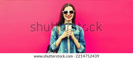 Portrait of happy smiling young woman with cup of coffee on pink background