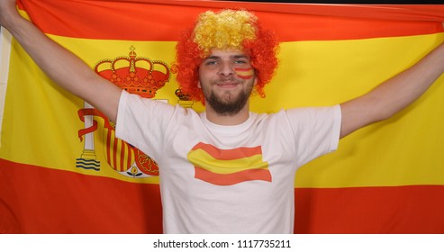 Portrait Of Happy Spanish Supporter Man Looking Camera Raise Hands With Spain Flag In International Football Sport Event