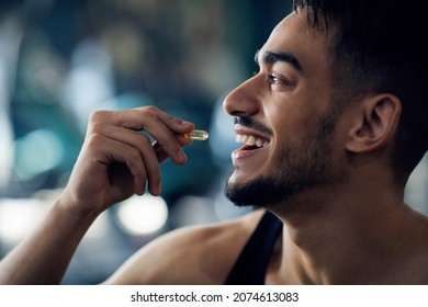 Portrait Of Happy Sportive Arab Man Taking Supplement Capsule, Closeup Shot Of Young Middle Eastern Guy Eating Omega 3 Or Amino Acid Multivitamin Pill, Enjoying Fitness Nutrition, Cropped