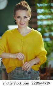 Portrait Of Happy Stylish Small Business Owner Woman In Yellow Sweater Standing In The Modern Green Office.