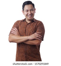 Portrait of happy successful Asian man wearing batik shirt smiling confidently wit arms crossed on his chest, isolated on white