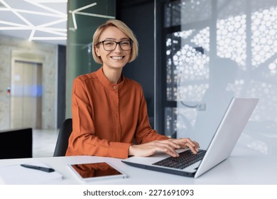 Portrait of happy and successful female programmer inside office at workplace, worker smiling and looking at camera with laptop blonde businesswoman is satisfied with results of achievements at work - Shutterstock ID 2271691093