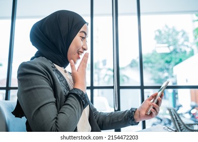 Portrait Of Happy Suprised Businesswoman With Hijab While Looking At Her Phone