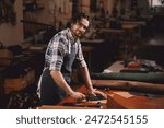 Portrait happy tailor working with natural brown leather in workshop. Small business of shoemaker cobbler.