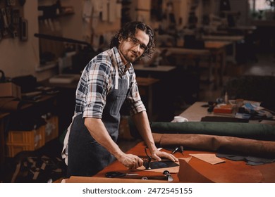 Portrait happy tailor working with natural brown leather in workshop. Small business of shoemaker cobbler. - Powered by Shutterstock