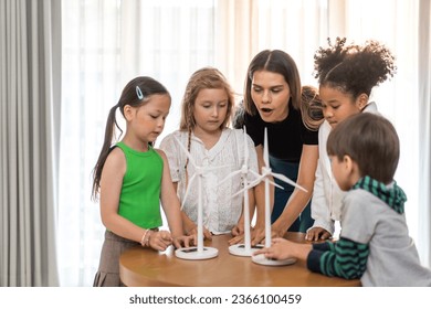 Portrait happy teacher help school children student having fun activity learn play renewable energy from solar windmill, education, science, environment, Eco, wind turbines, class at elementary school - Powered by Shutterstock