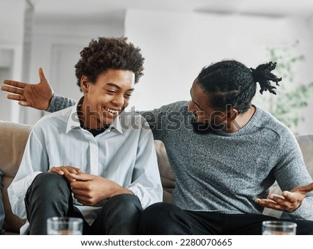 Portrait of a happy teenage boy son talking to his father at home. Sharing secrets and having fun, support and parenthood concept