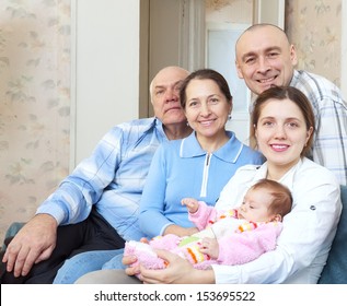 Portrait Of Happy Three Generations Family With Newborn Baby At Home