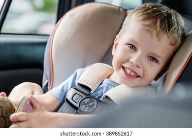 Portrait Happy Toddler Boy Sitting In The Car Seat