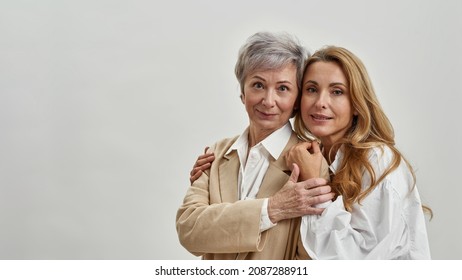 Portrait Of Happy Two Older And Younger Generations Of Caucasian Women Isolated On White Studio Background. Copy Space. Loving Adult Daughter Hug Mature Mother Feel Thankful. Gratitude And Care.