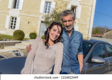 Portrait Of Happy Wealthy Middle Age Couple Outside Of Their House