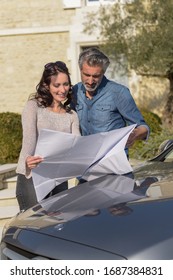 Portrait Of Happy Wealthy Middle Age Couple Studying A New Archi