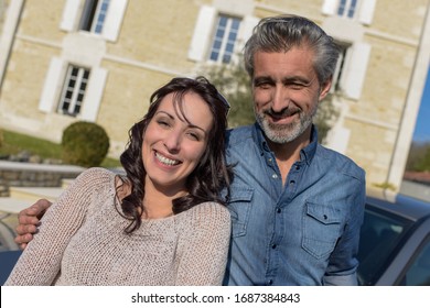 Portrait Of Happy Wealthy Middle Age Couple Outside Of Their Hou