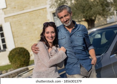 Portrait Of Happy Wealthy Middle Age Couple Outside Of Their House