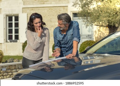 Portrait Of Happy Wealthy Middle Age Couple Studying A New Architecture  Project For Their House