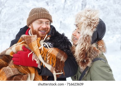 portrait of happy winter couple with pet small dog scottish terrier. Young man and woman in love walking in the snowy forest - Powered by Shutterstock