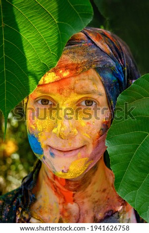 Portrait of a happy woman after Holi festival with colorful makeup