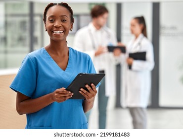 Portrait of happy woman doctor working on a digital tablet and smile while working at a hospital. Black female nurse doing medical and healthcare research on the internet or online at work at clinic - Shutterstock ID 2199181483