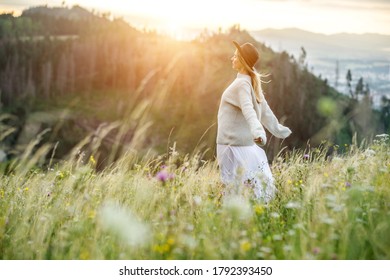 Portrait happy woman enjoying sunset stay on the green grass on the forest peak of mountain. Fresh air, Travel, Summer, Holidays, Journey, Trip, Lifestyle.