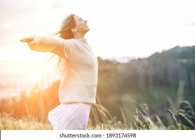 Portrait glückliche Frau genießen Sonnenuntergang auf dem grünen Gras auf dem Waldgipfel des Berges. Frische Luft, Reisen, Sommer, Herbst, Urlaub, Reise, Ausflug, Lifestyle.