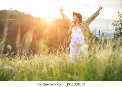 Portrait happy woman enjoying sunset stay on the green grass on the forest peak of mountain. Fresh air, Travel, Summer, Fall, Holidays, Journey, Trip, Lifestyle.