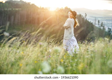 Portrait glückliche Frau genießen Sonnenuntergang auf dem grünen Gras auf dem Waldgipfel des Berges. Frische Luft, Reisen, Sommer, Herbst, Urlaub, Reise, Ausflug, Lifestyle.
