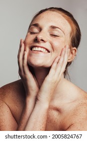 Portrait Of Happy Woman With Freckles On Body. Close Up Of Smiling Woman With Hands On Face With Closed Eyes.