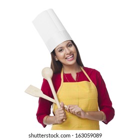 Portrait Of A Happy Woman Holding A Spatula And Ladle