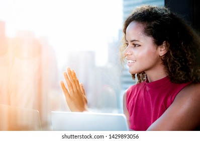 Portrait Of Happy Woman Looking Through The Window With Hands On The Glass And Say Hi.Young Lady Waiving And Saying Hello And Smiling,friendly Welcome Gesture Through Glass Window On High Building.