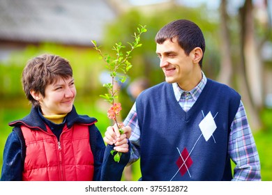 portrait of happy woman and man with disability together on spring lawn