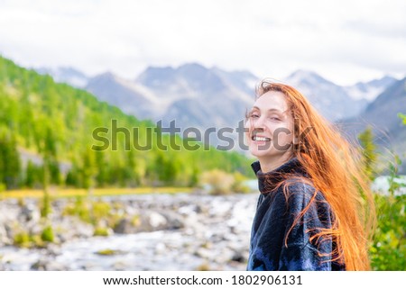 Portrait of a happy woman on the background of mountains and multinsky lake