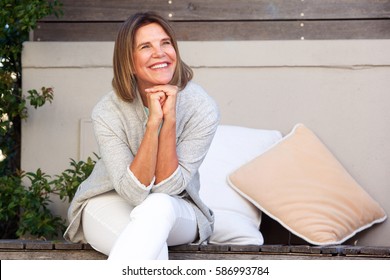 Portrait Of Happy Woman Sitting Outside Looking Away