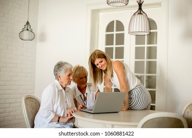 Portrait of happy women of three generations using laptop  in the room at home - Powered by Shutterstock