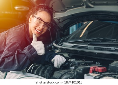 Portrait happy working woman work for auto mechanic job in garage hand thumbs up sign for good condition car engine - Powered by Shutterstock