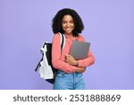 Portrait of happy young African American girl holding laptop standing isolated on purple background, smiling female student with backpack computer looking away advertising education program abroad.