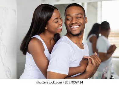 Portrait of happy young african american couple embracing near mirror in bathroom, cheerful romantic black millennial spouses hugging and laughing, enjoying spending morning time together, closeup - Powered by Shutterstock