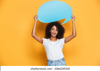 Portrait Of A Happy Young African Woman Holding Empty Speech Bubble Isolated Over Yellow Background