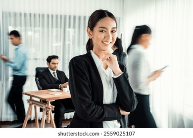 Portrait of happy young asian businesswoman looking at camera with motion blur background of business people movement in dynamic business meeting. Habiliment - Powered by Shutterstock