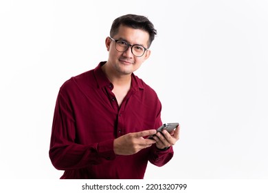 Portrait Of Happy Young Asian Man Handsome Happy Smile In Formal Red Shirt Using Smartphone Trading Or Chatting In Studio White Isolated Background.