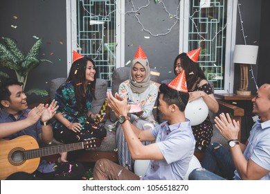 Portrait Of Happy Young Asian People Celebrating And Singing Birthday Of Their Friends Together At Home