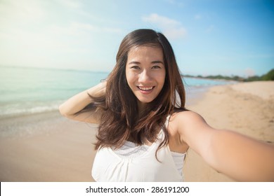 A portrait of a Happy young Asian woman take selfie, smile to camera