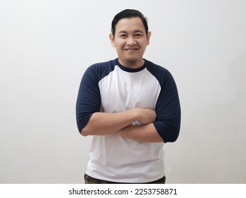 Portrait of happy young attractive cute Asian man smiling cheerfully, confident friendly gesture with arms crossed, against grey background - Shutterstock ID 2253758871