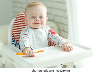 Portrait Of Happy Young Baby Boy In High Chair
