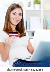 Porträt einer glücklichen jungen schönen Frau mit Kreditkarte und Laptop