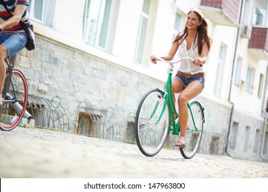 Portrait Of Happy Young Bicyclist Riding In Park