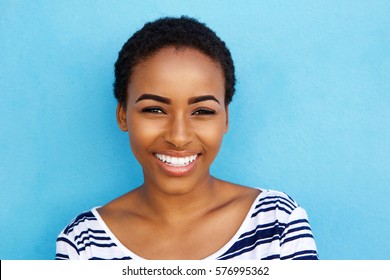 Portrait Of Happy Young Black Woman Smiling Against Blue Background