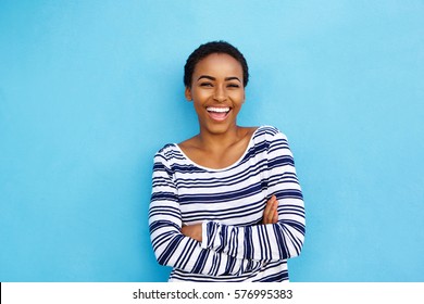 Portrait happy young black woman laughing against blue wall