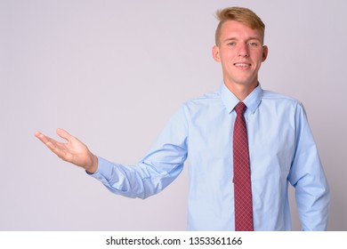 Portrait Of Happy Young Blonde Businessman Showing Something