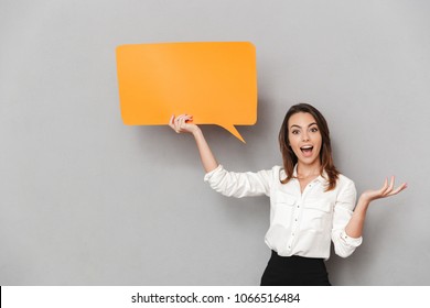 Portrait Of A Happy Young Business Woman Holding Empty Speech Bubble Isolated Over White Background