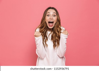 Portrait of a happy young casual girl screaming isolated over pink background - Shutterstock ID 1152936791